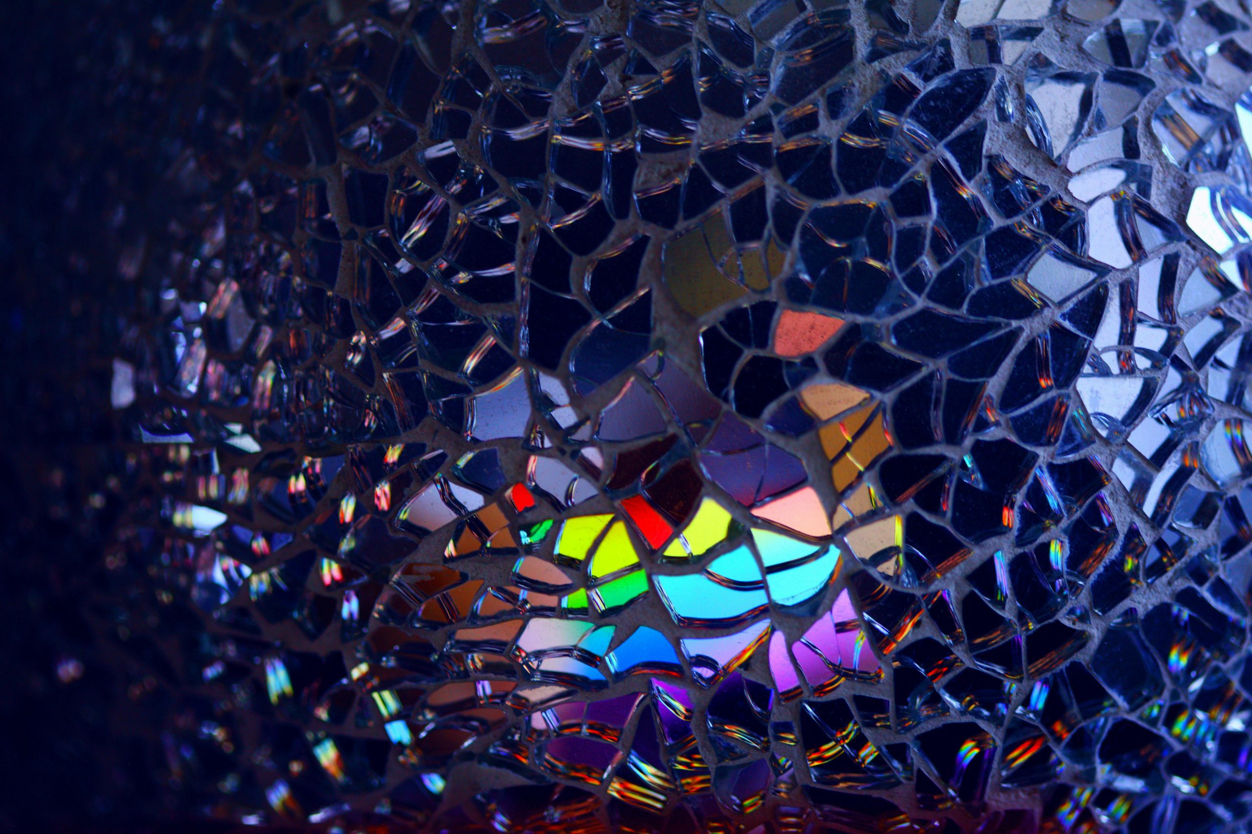 A colorful rainbow reflection through broken glass.